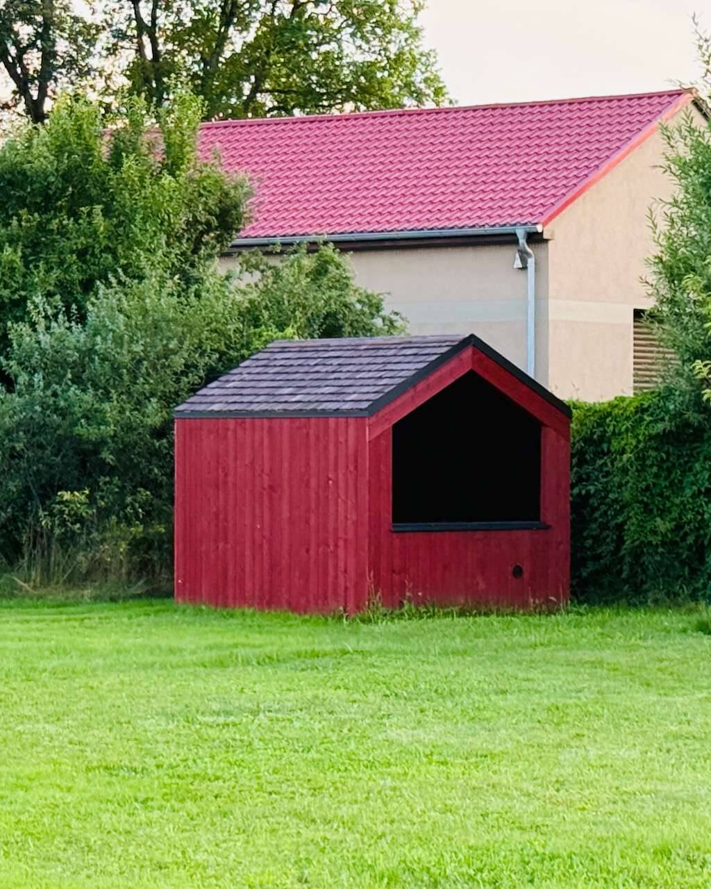 Barn Nordic in schönem Rot in idyllischer Gartenlandschaft eingebettet