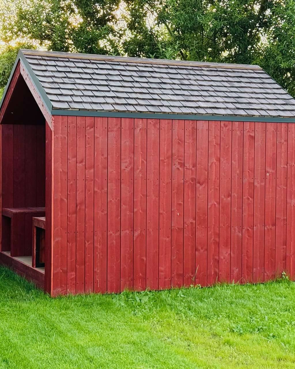 Barn Nordic in schönem Rot in idyllischer Gartenlandschaft in saftiger grüner Umgebung