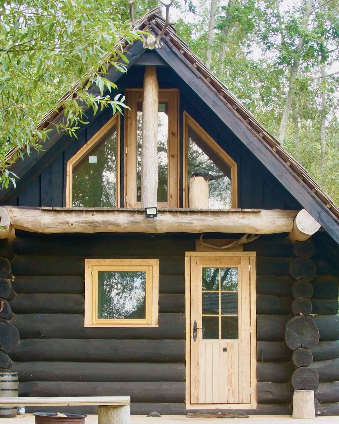 Schwarzes Rundstamm Ferienhaus idyllisch im Wald
