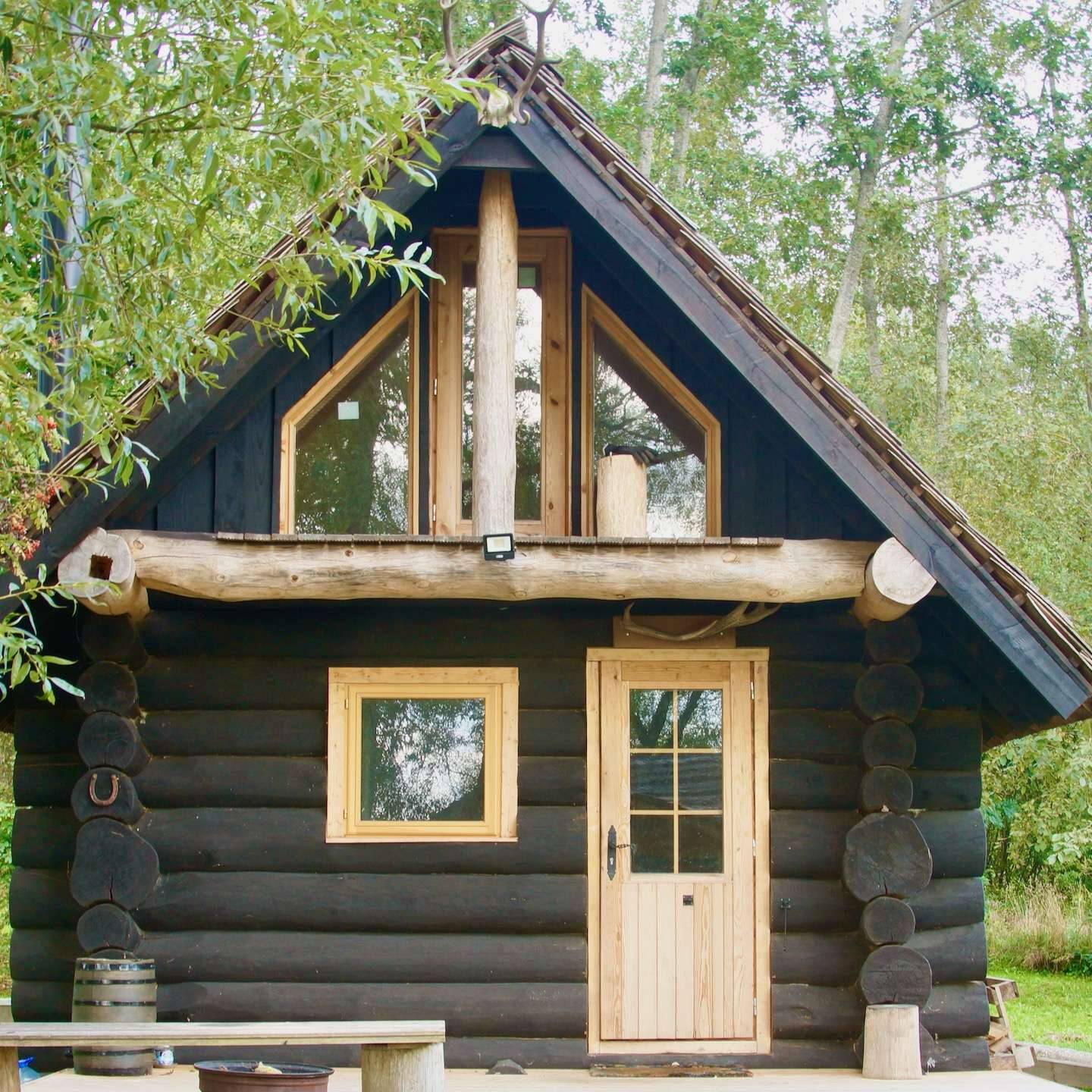 Schwarzes Rundstamm Ferienhaus idyllisch im Wald