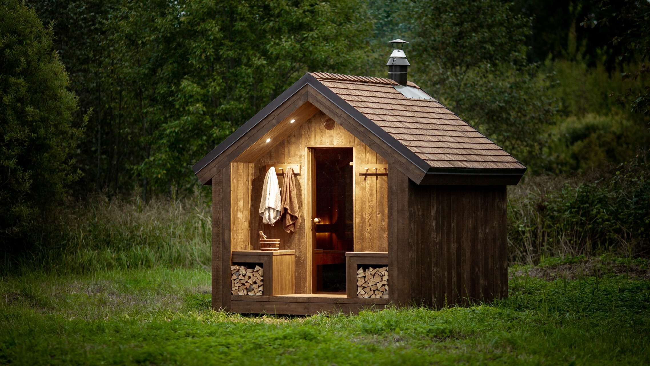 Rustikale Gartensauna Shack Ansicht seitlich mit LED Stimmungslicht – ManoKin Manokin Gartensauna Guide: Welche passt zu mir?