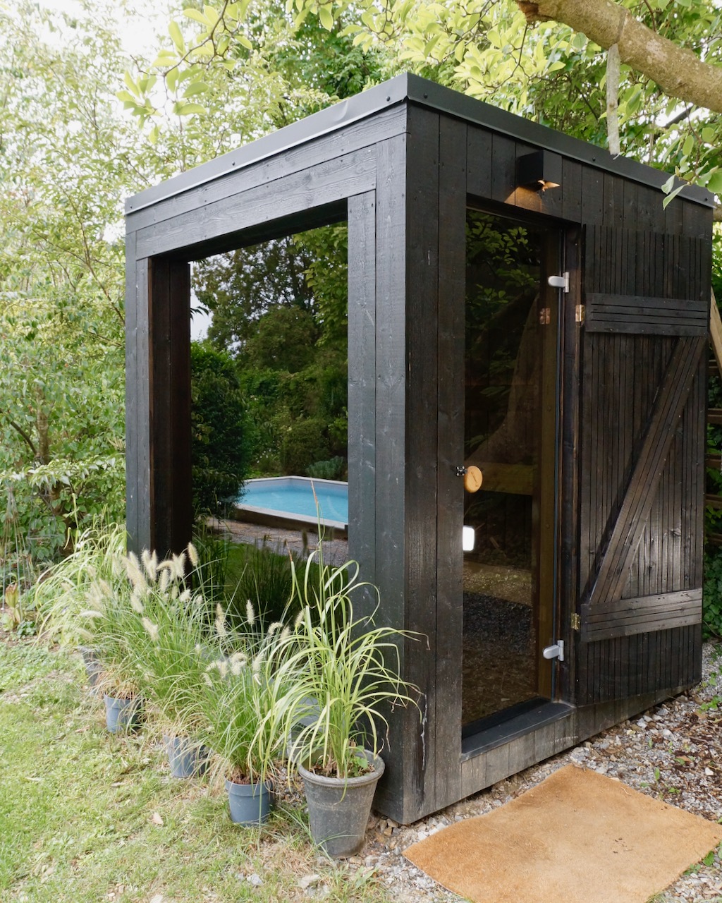 Schwarze Sauna mit Aussenbeleuchtung ueber Saunatuer – ManoKin Schwarze Sauna mit Außenbeleuchtung über Saunatür