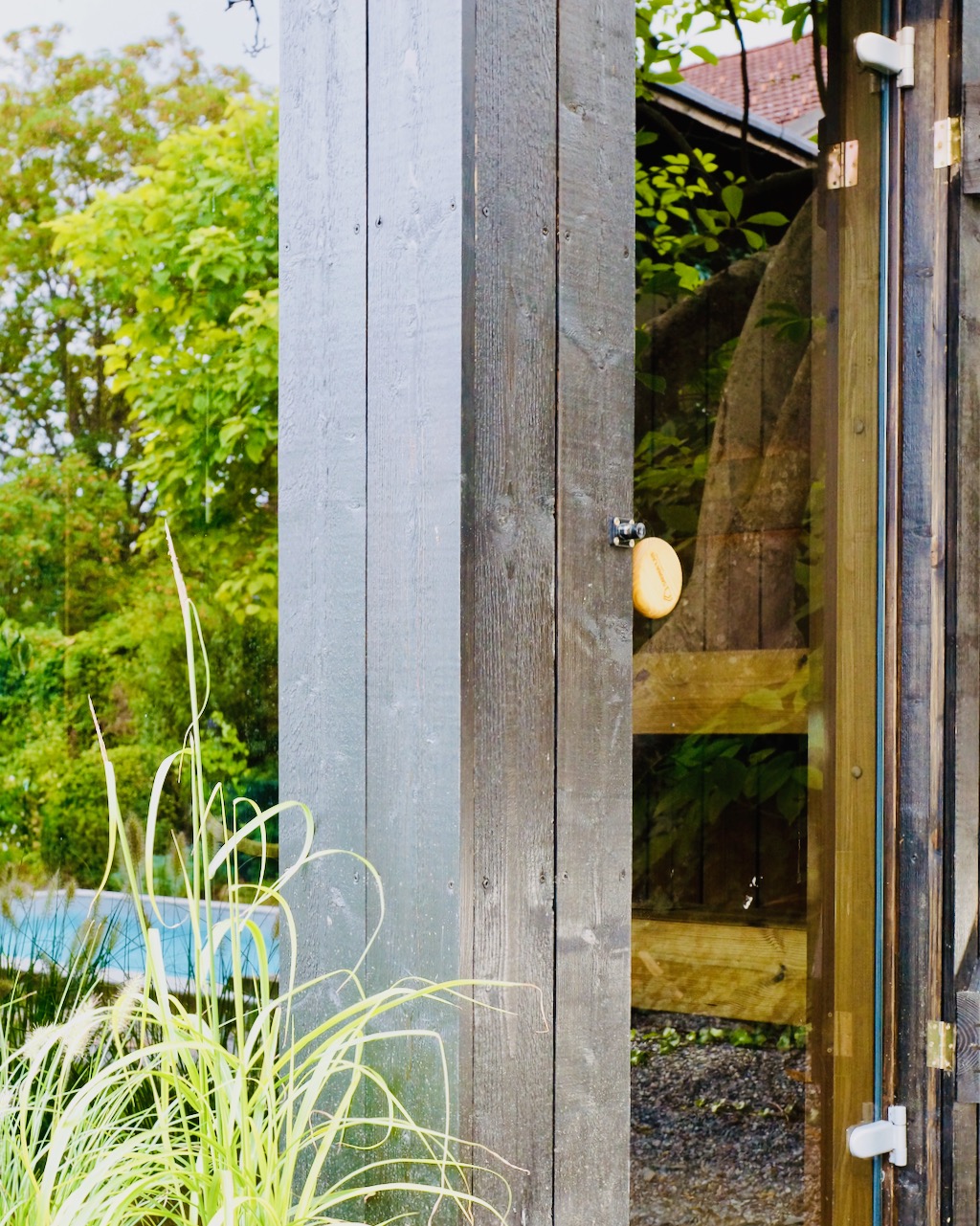Schwarze Sauna mit lasierter Fassade – ManoKin Schwarze Sauna mit lasierter Fassade