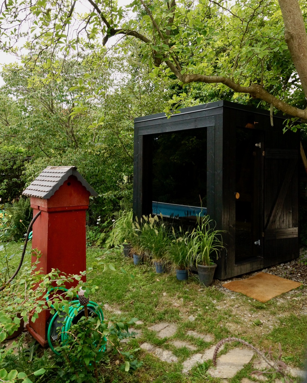 Schwarze Sauna mit rotem Wasserhaus – ManoKin Schwarze Sauna mit rotem Wasserhaus
