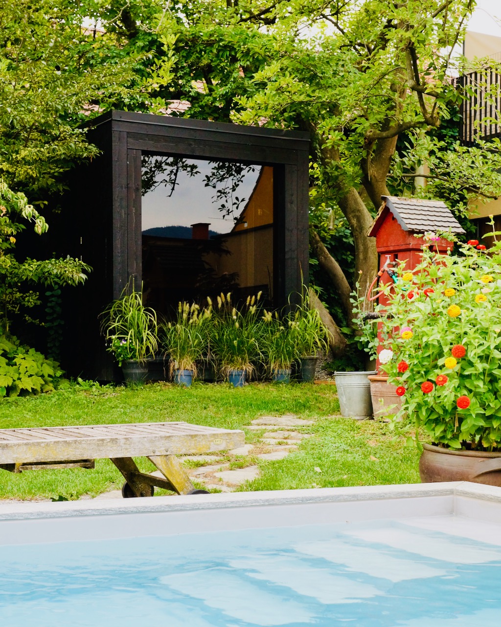 Schwarze Sauna mit tuerkisen Pool – ManoKin Schwarze Sauna mit türkisen Pool
